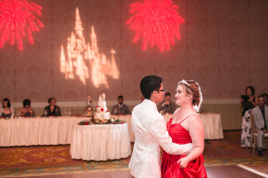 Romantic Disney wedding photography in Orlando featuring a red beauty and the best theme captured by top Orlando wedding photographer and videographer