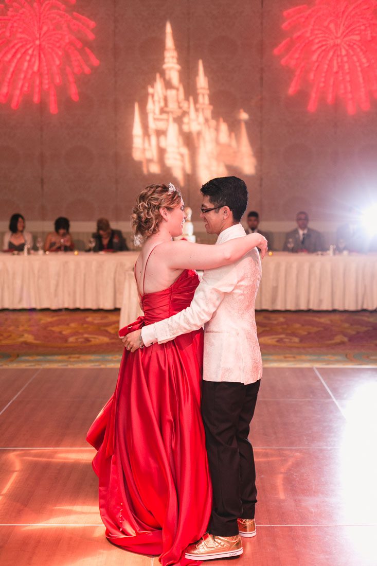 Romantic Disney wedding photography in Orlando featuring a red beauty and the best theme captured by top Orlando wedding photographer and videographer