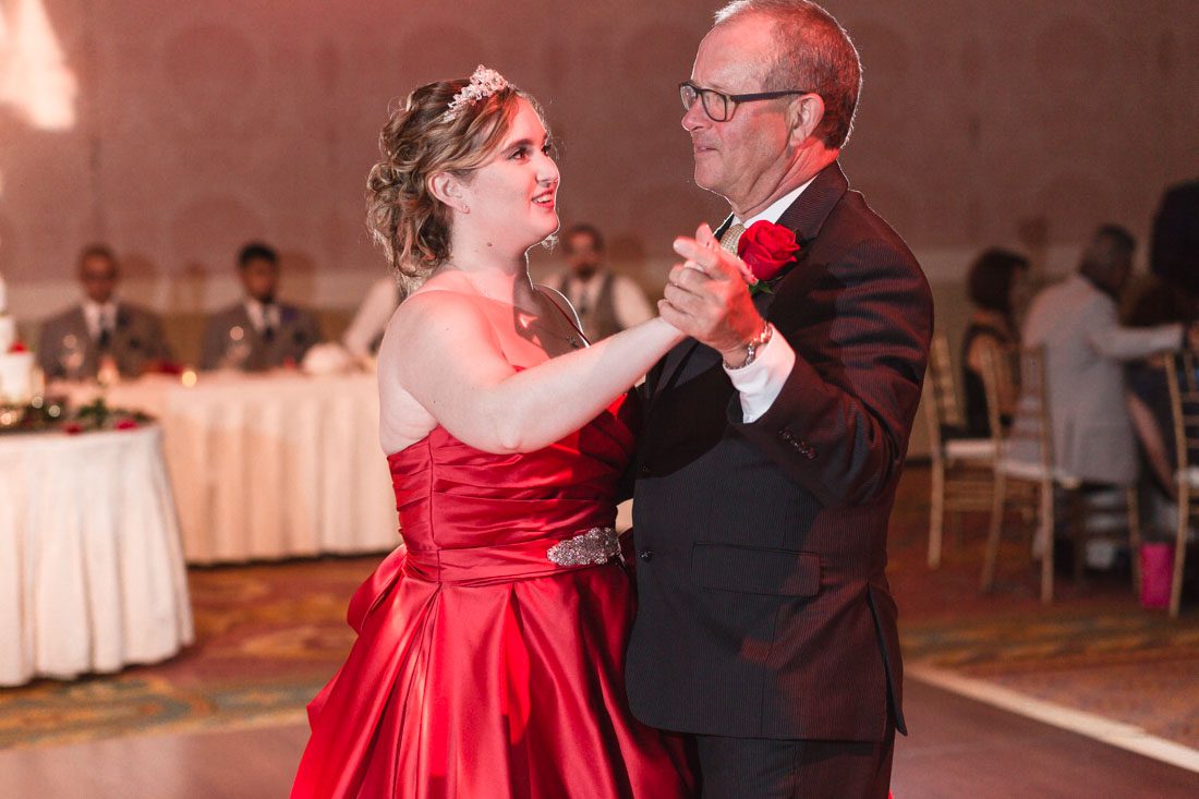 Romantic Disney wedding photography in Orlando featuring a red beauty and the best theme captured by top Orlando wedding photographer and videographer