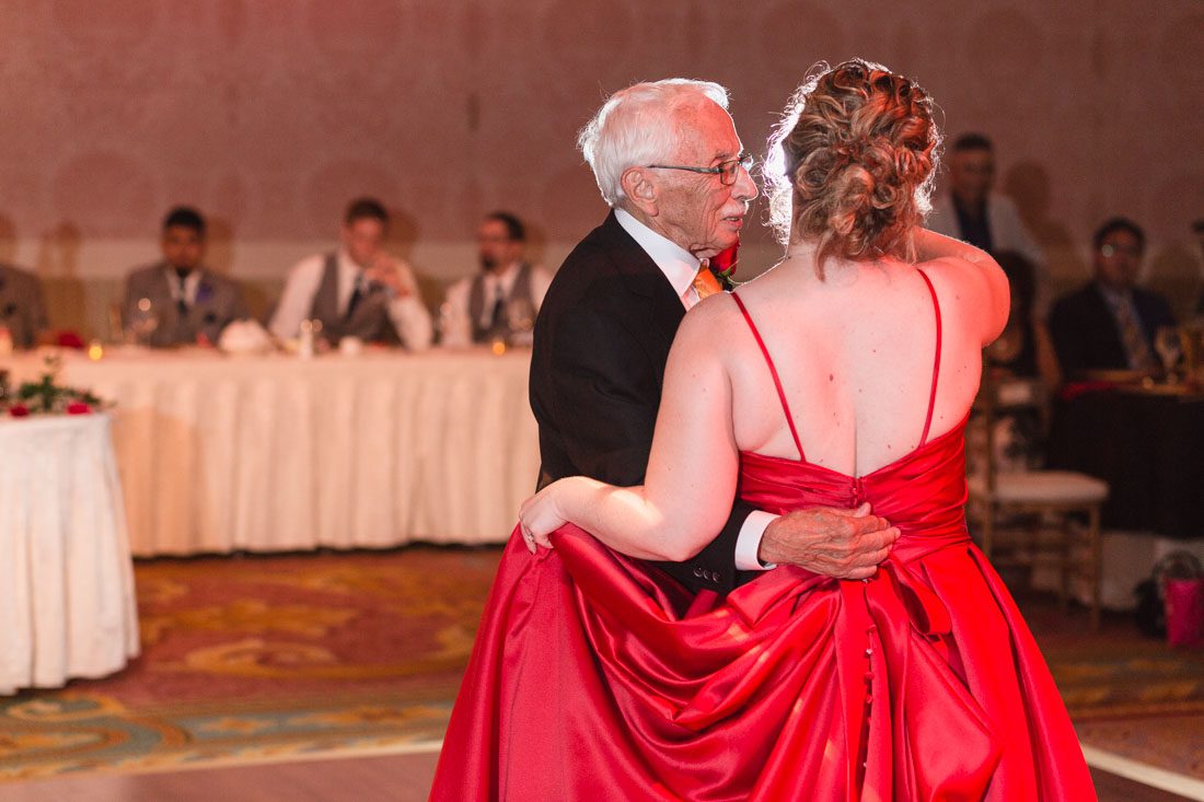Romantic Disney wedding photography in Orlando featuring a red beauty and the best theme captured by top Orlando wedding photographer and videographer