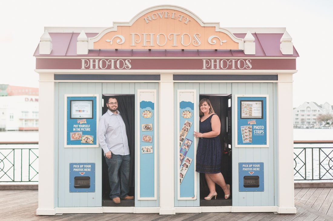 Engaged couple posing in a photo booth at Disney Boardwalk with top Orlando engagement photographer