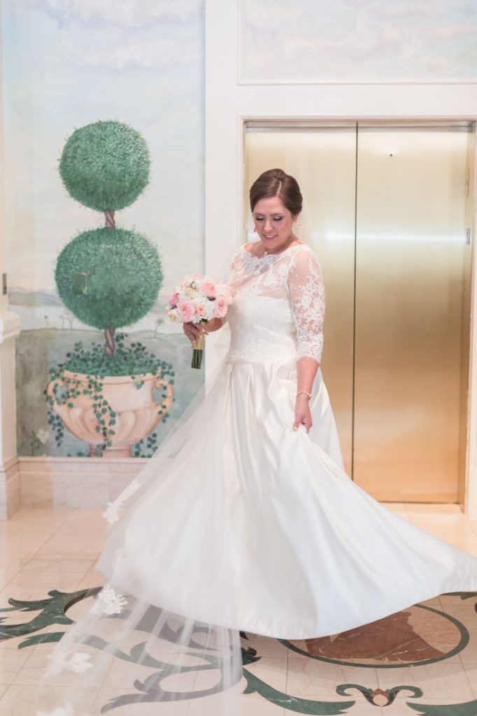 Disney brides poses in her David Tutera wedding dress at the Grand Floridian by Orlando photographer