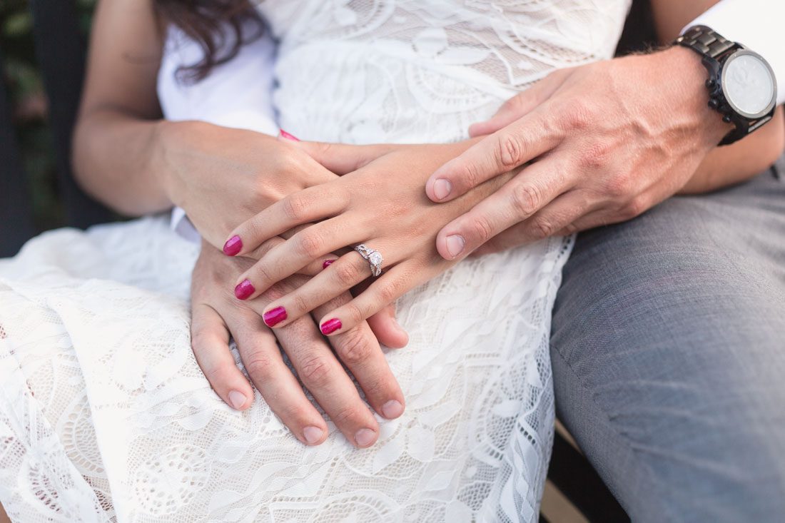 Close up of the future bride's engagement ring with her fiance during their engagement portrait session in Winter Garden, Florida