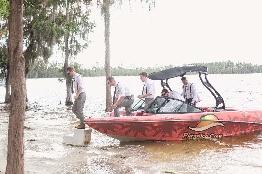 Groom and groomsmen arrive on a speedboat for their Paradise Cove wedding in Orlando Florida