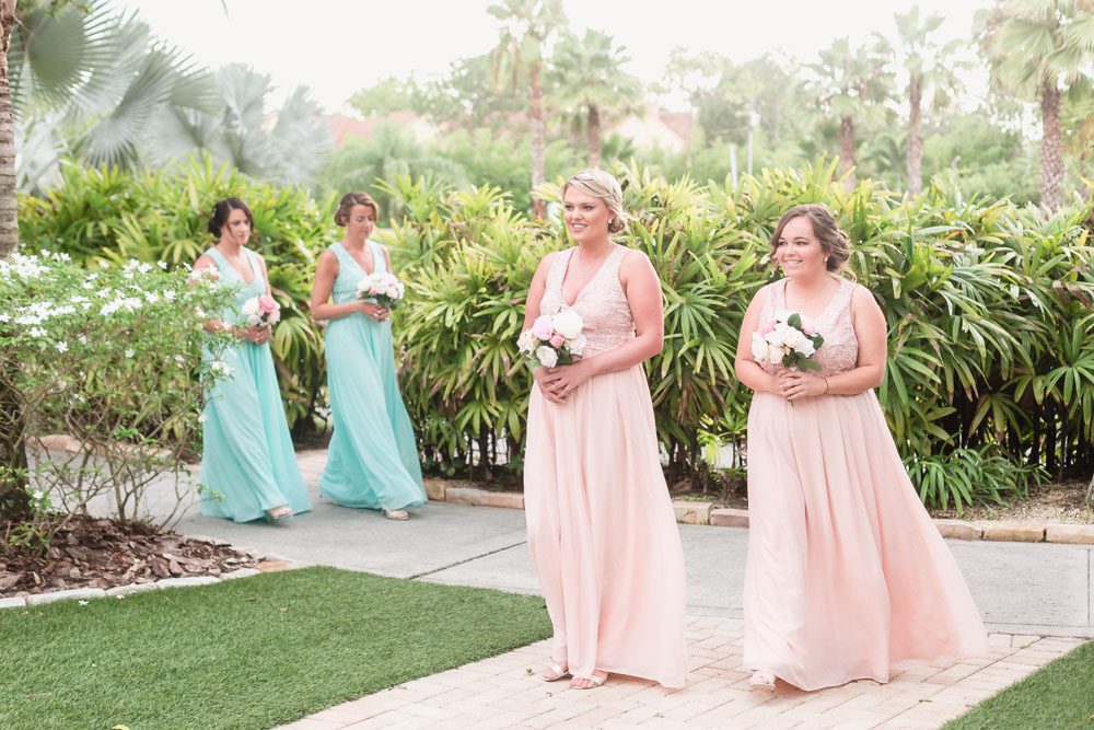 Bridesmaids entering the wedding ceremony at Paradise Cove in blush pink and turquoise blue dresses