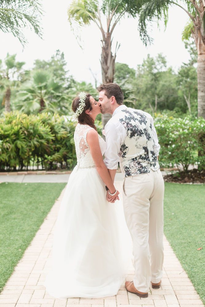 Romantic portrait of the bride and groom during their tropical beach wedding at Paradise Cove captured by top Orlando wedding photographer