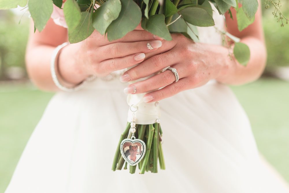 The bride shows off her pretty wedding day nails and commemorative bridal charm on her wedding day in Orlando