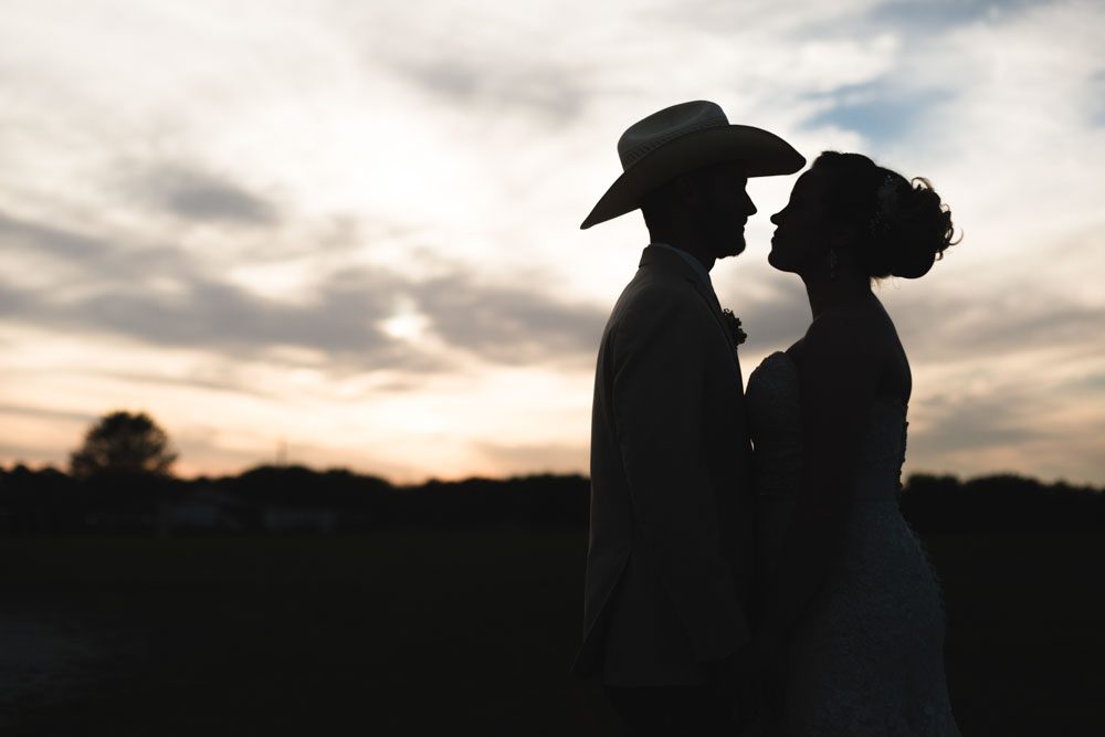 Romantic silhouette of a country wedding at sunset during their rustic wedding day in Central Florida
