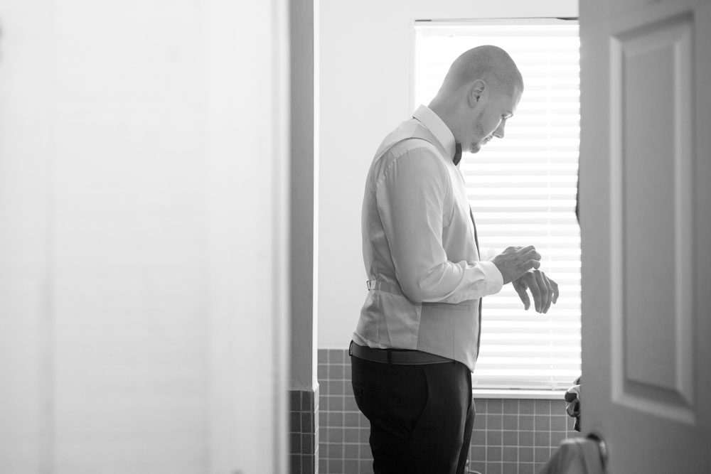 Black and white photo of the groom getting ready for his intimate wedding day in Kissimmee Florida