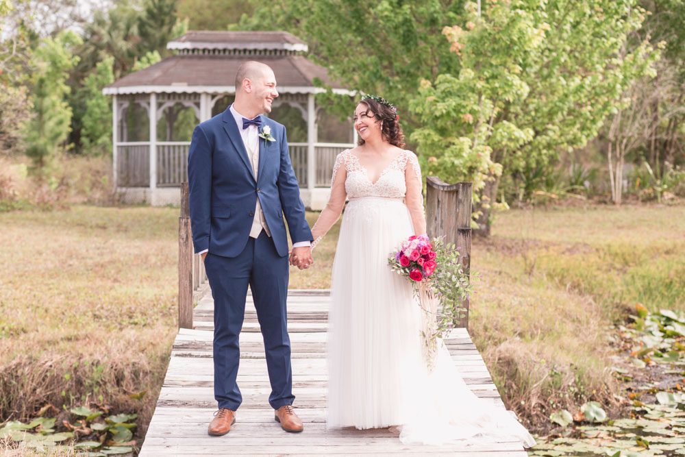 Bride and groom portrait on a dock during their romantic intimate backyard wedding day in Kissimmee Florida captured by top Orlando wedding photographer and videographer