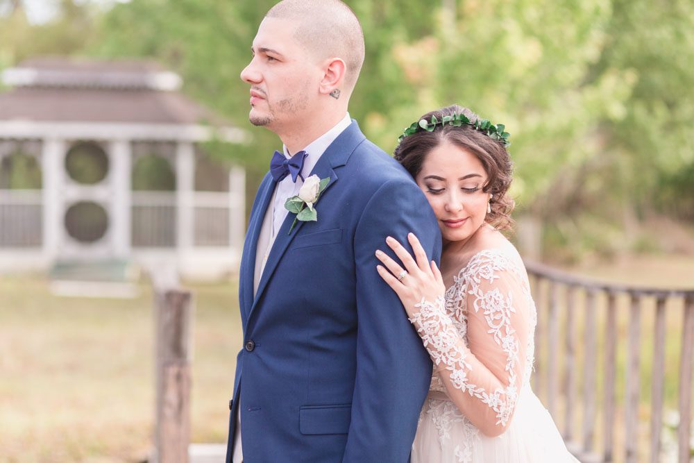 Bride and groom portrait on a dock during their romantic intimate backyard wedding day in Kissimmee Florida captured by top Orlando wedding photographer and videographer