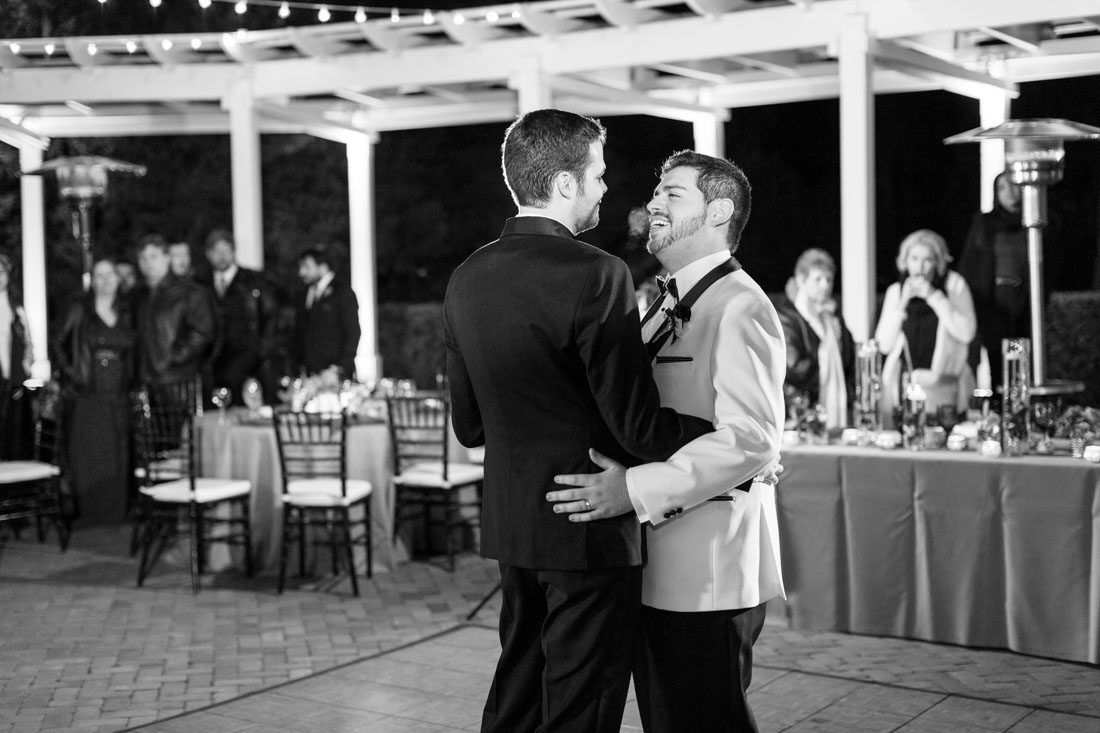 Gay grooms share their first dance outdoors during their reception at Cypress Grove Estate House in Orlando