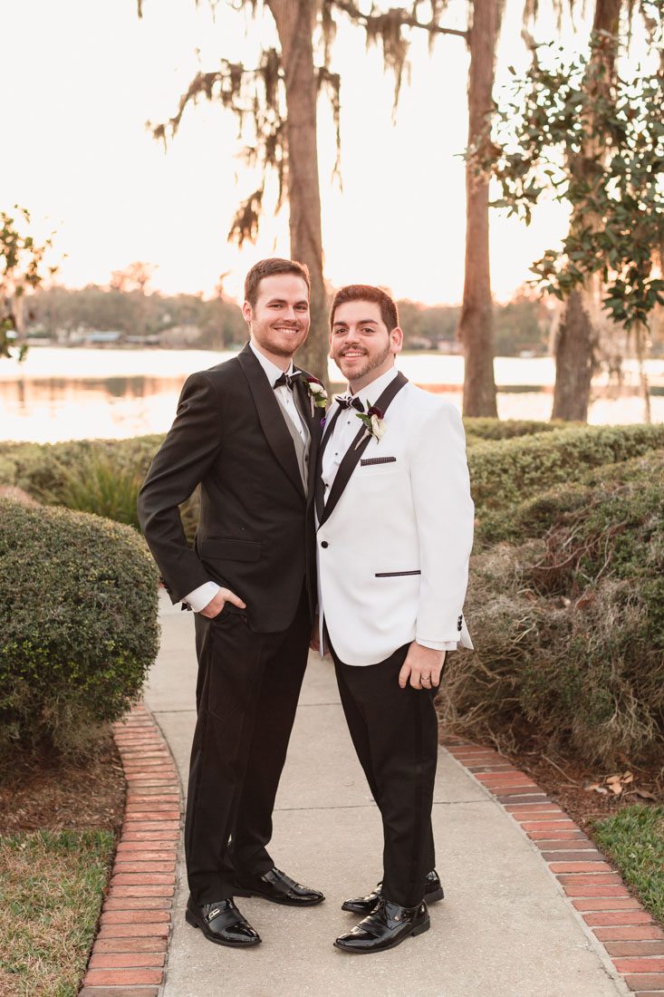 Portrait of two grooms at their gay wedding at sunset by the water in Orlando Florida