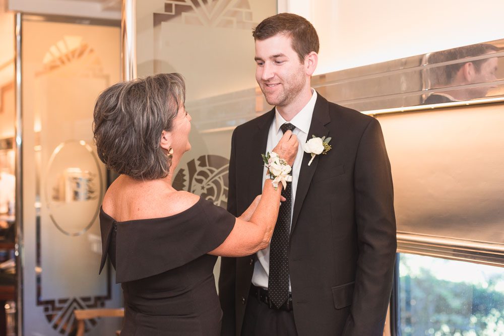 Groom getting ready with his mom at the Estate on the Halifax train captured by top Orlando wedding photographer