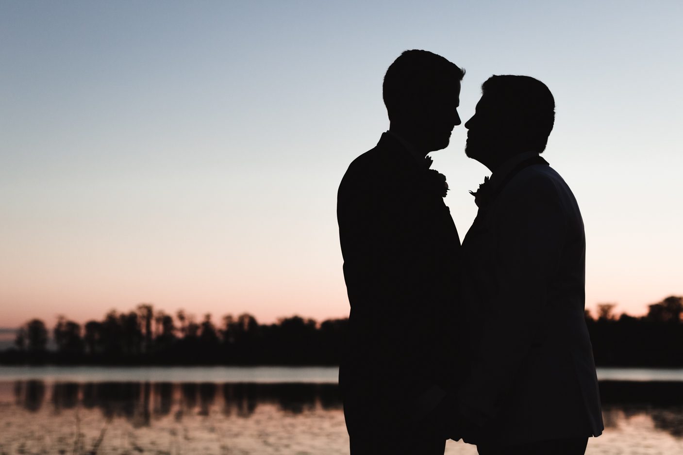 Silhouette of two grooms during gay wedding in Orlando at sunset at Cypress Grove