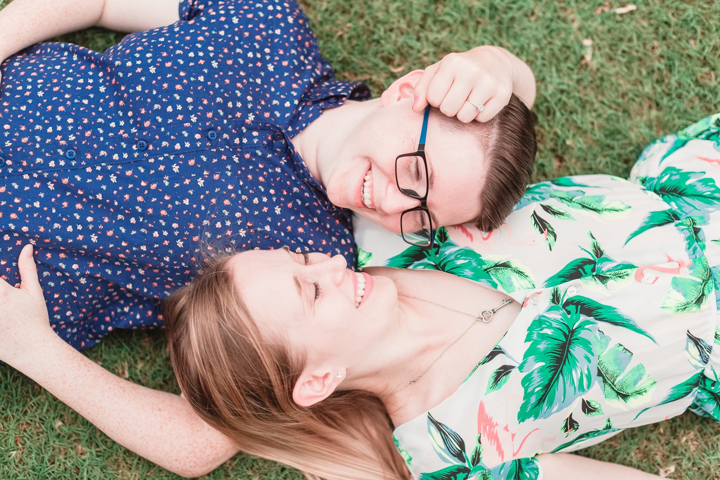 Lesbian engagement photo laying in the grass captured by top Orlando gay friendly wedding photographer