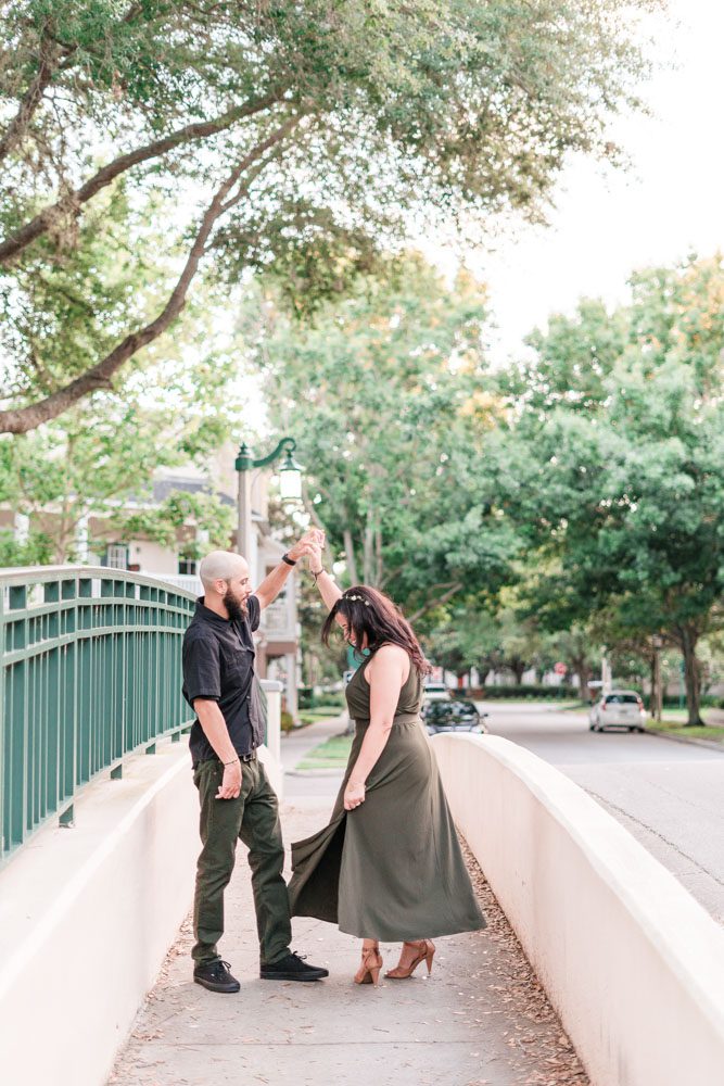 Fun and playful twirling engagement photo on a bridge in Celebration Florida captured by top Orlando photographer