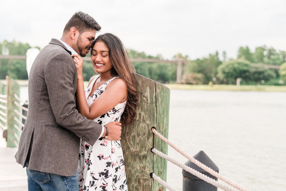 Candid and romantic engagement photo on the dock at the Grand Floridian captured by top Orlando engagement photography team