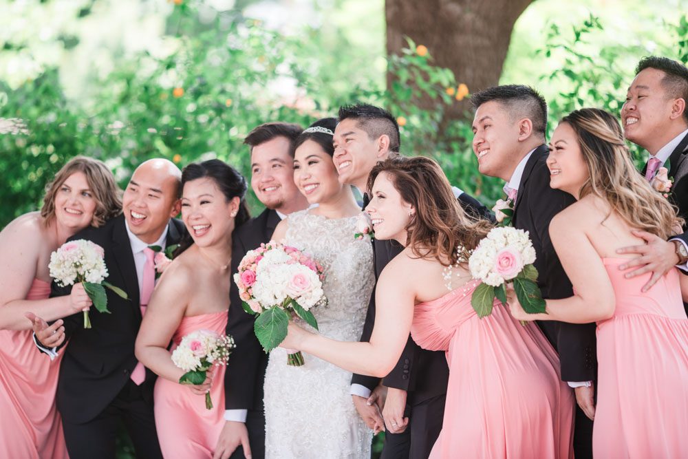 Fun candid photo of the wedding party wearing pink bridesmaid dresses captured by top Orlando wedding photographers
