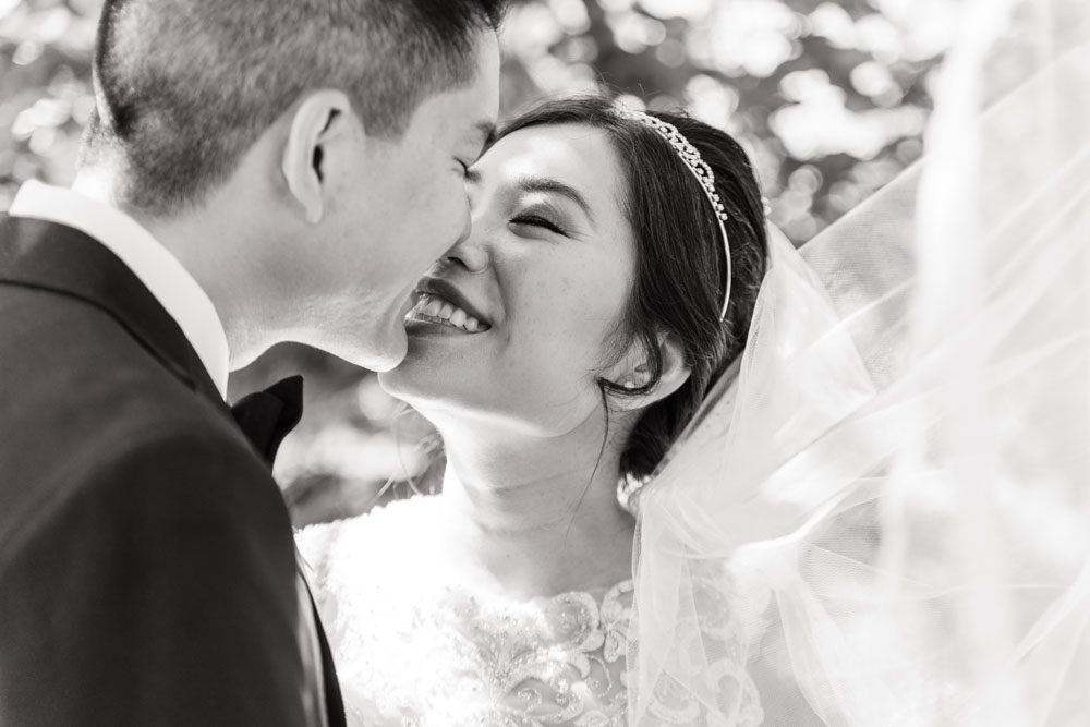 Black and white portrait of Asian bride and groom under veil captured by top Orlando wedding photographer