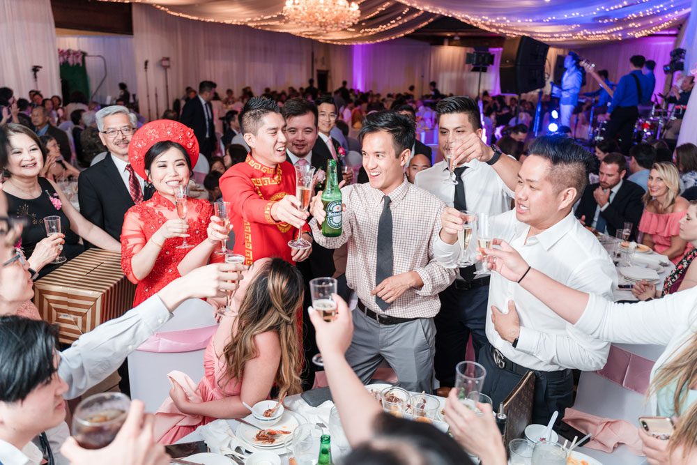 Chinese bride and Vietnamese groom share a toast with their guests at Hy Palace wedding in Oklahoma captured by traveling photographers from Orlando