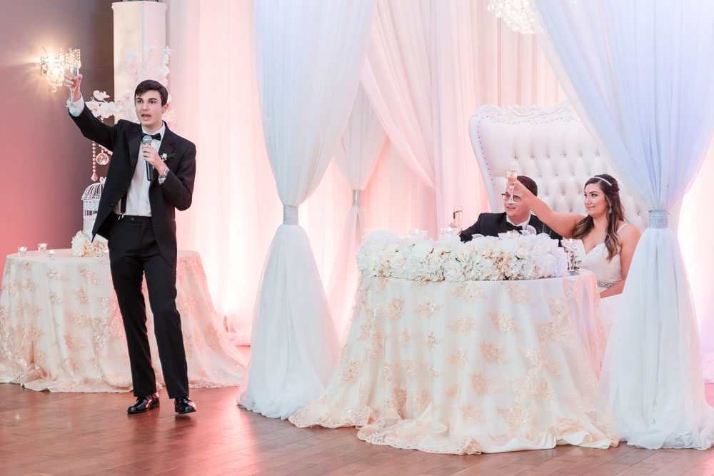 Couple receives a toast at their wedding reception at the Crystal Ballroom veranda captured by Orlando wedding photographer and videographer