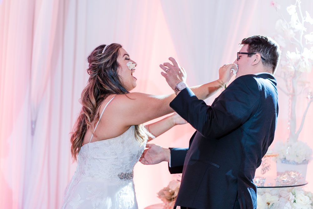 Couple shares their first slice of wedding cake during their Orlando reception at the Crystal Ballroom in MetroWest