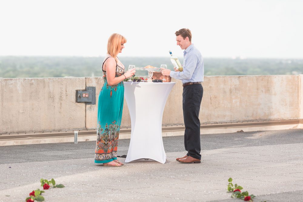 Orlando rooftop surprise proposal featuring roses, wine and the downtown skyline at sunset