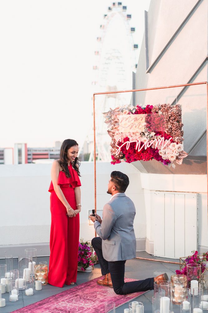 Orlando engagement photographer captures a surprise proposal at The Castle Hotel with sunset views of the ferris wheel